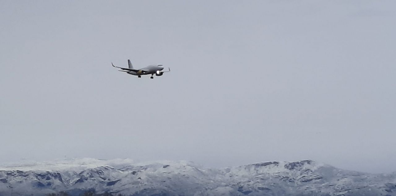 Fotografia desde la playa de Gava, de un avion sobrevolando el Massis del Garraf nevado (Foto: Xavi Cabo)