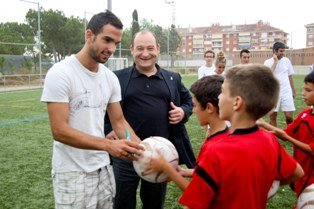Martín Montoya signa una pilota a un jove jugador del CD Viladecans