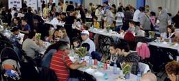 Dues-centes persones comparteixen taula i cooperació en els Menjars d’Arreu del Món