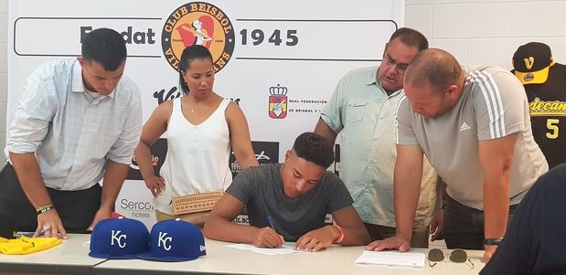 Omar arropado por su familia junto a los representantes del equipo americano en el momento de la firma del contrato.