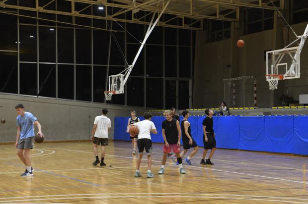 Jóvenes jugando a baloncesto indoor en el Poliesportiu Municipal de Can Vinader. El programa "A la nit, una altra moguda" tiene como objetivo principal ofrecer una alternativa de ocio nocturno seguro y libre de violencias.