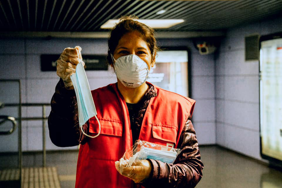 Una voluntaria de Creu Roja Cornellà reparte mascarillas en una estación.