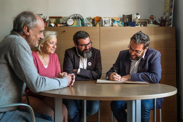 Fernández firmando el Libro de Honor del Ayuntamiento de Collbató, junto al alcalde Solà (a su derecha) y los dos tenientes de alcalde.