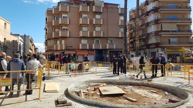 Policias y vecinos en la Plaza de las Palmeras de Viladecans durante los registros policiales. 