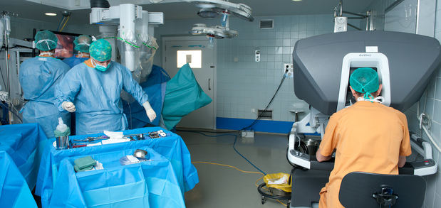Intervención urológica donde se puede ver al cirujano operando a distancia desde una consola.
