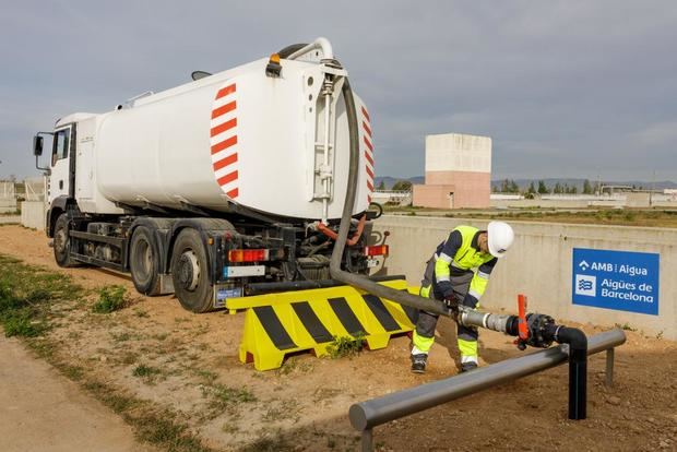 Operario conectando el camión cisterna a la fuente de agua regenerada