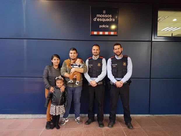 La familia del bebé junto a los dos agentes de los mossos que con su rápida intervención ayudaron a salvarle la vida.
