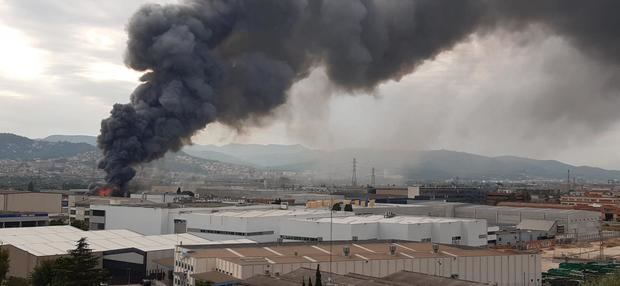 La espectacular humareda del incendio de una fábrica obliga a confinar Sant Feliu