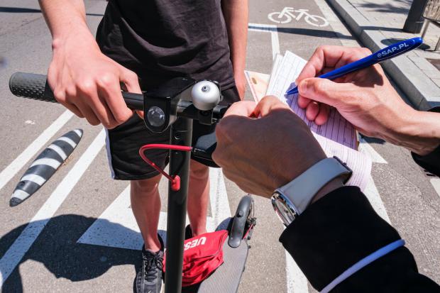 Un sancionador multando a un ciudadano que utilizaba un patinete eléctrico