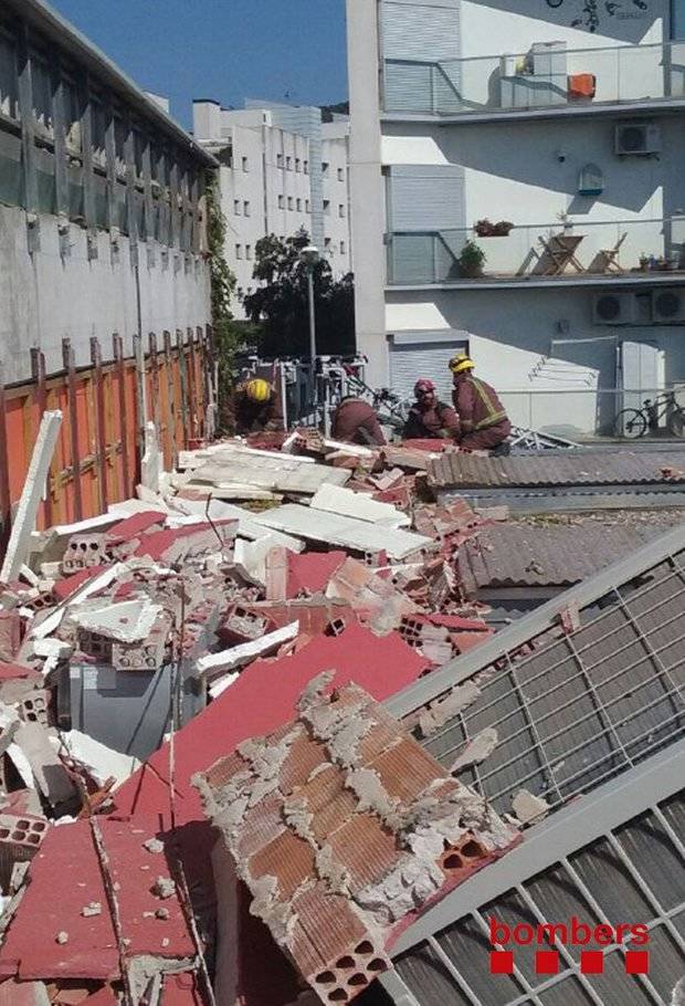 Un equip de Bombers treballa sobre el mur enfonsat