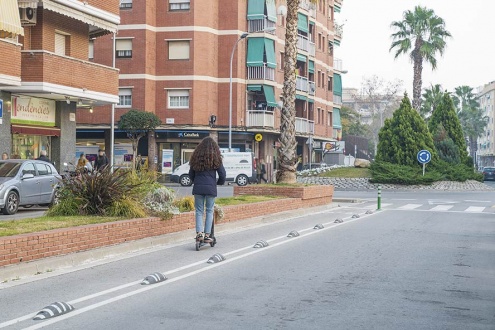 Una mujer transita en patinete eléctrico por El Prat.