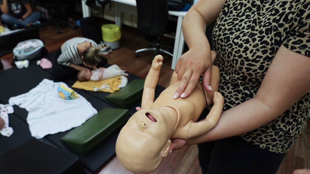  Una mujer del grupo de posparto del ASSIR Ramona Via practica la técnica de primeros auxilios de presionar con dos dedos el centro del pecho con un maniquí de reanimación