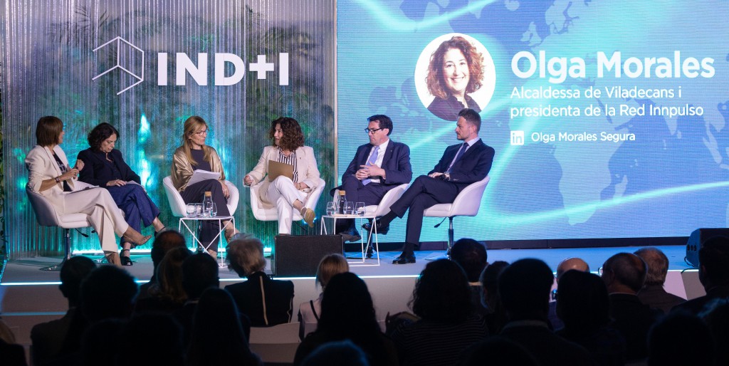olga morales (Sentada en el centro, de blanco) durante la bienvenida instituacional que dio inicio a las jornadas IND+I 2025 de viladecans