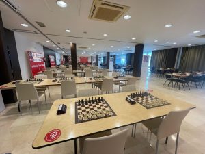 Sala preparada para el torneo de ajedrez Open Chess con mesas y tableros.